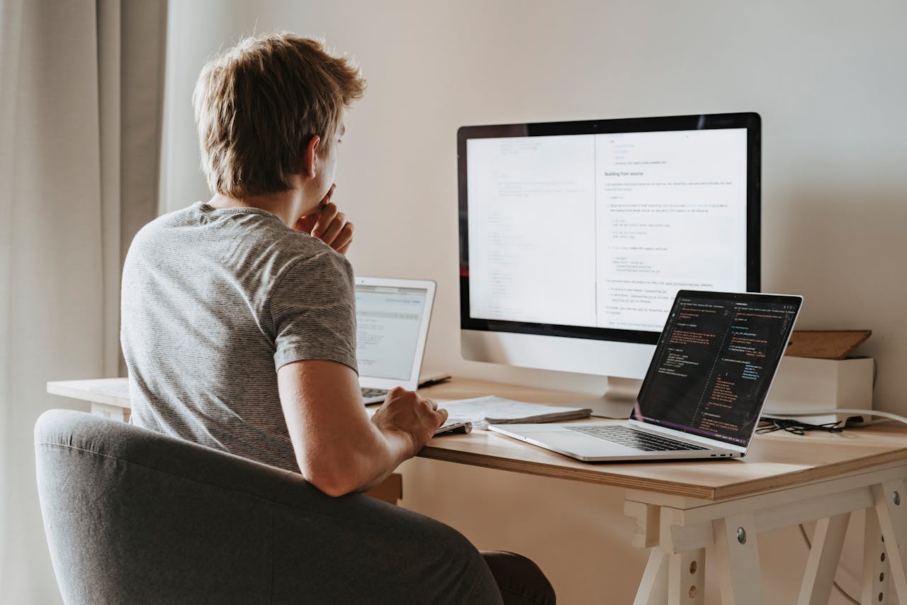 man sitting at computer building website